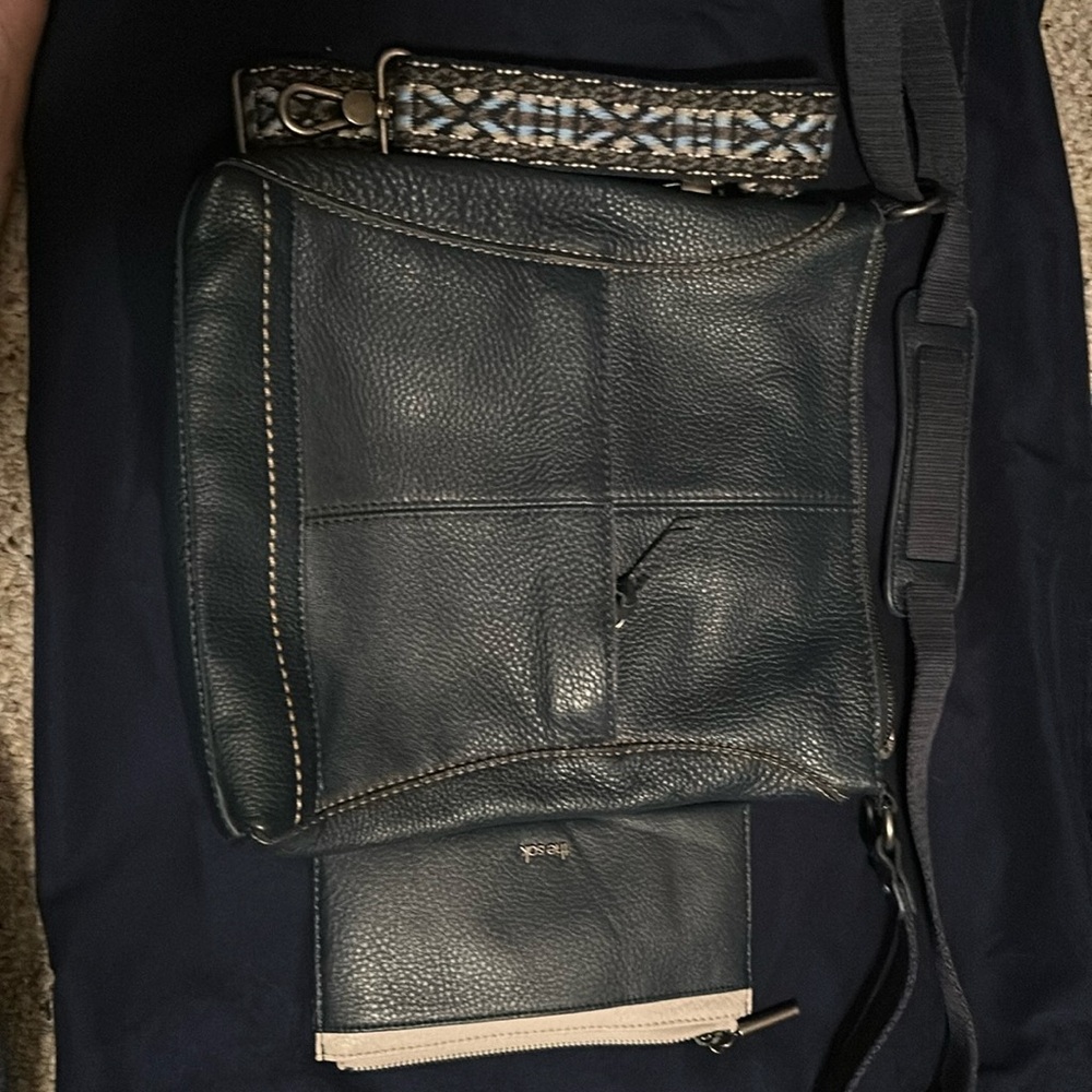 The Sak messenger purse with wallet and extra strap navy blue in color.